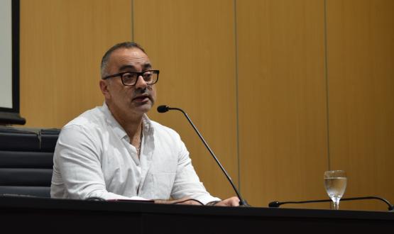 Foto. Federico Beltramelli tras ser designado como decano de la FIC. Beltramelli habla a los claustristas desde el estrado del aula magna. 