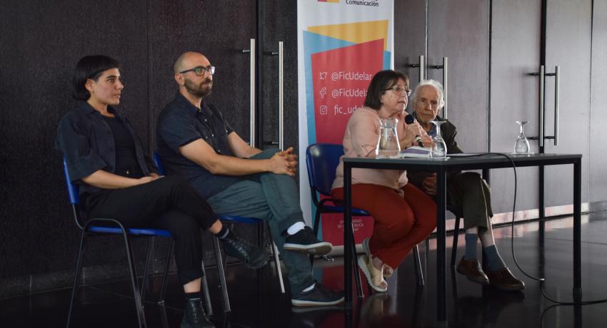 Fotografía en la que se a Gladys Ceretta hablando junto a Mariana García, Felipe Rebellato, y Octavio Podestá sentados en una mesa