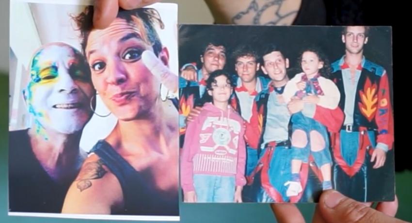 Primer plano de dos manos sosteniendo dos fotos, en una una mujer y un hombre con la cara pintada, en otra un grupo de gente, algunos con vestuario de carnaval. 