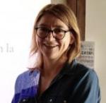 Fotografía, plano medio de una mujer sonriente, castaña, de pelo lacio por la altura de los hombros, de lentes. 