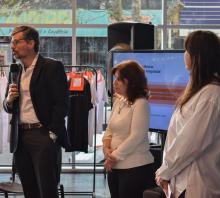 Foto de la apertura de las Jornadas. De pie, en el hall de la FIC el prorrector de Extensión Rafael Paternain tomando la palabra, a su lado la docente Paulina Szafran y la coordinadora de la UDEA Romina Verrua. Ambas lo miran. 