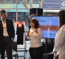 Foto de la apertura de las Jornadas. En el hall de la FIC, de izquierda a derecha están parados Rafael Paternain, Paulia Szafran y Romina Verrua. Szafran habla al auditorio. 