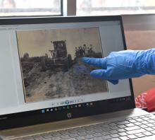 Estudiante editando foto histórica de San Luis en la computadora