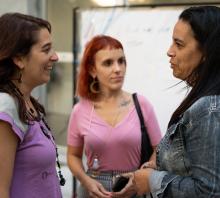 Foto. Encuentro de Mujeres del ASA. Tres trabajadoras de distintos servicios conversando. 